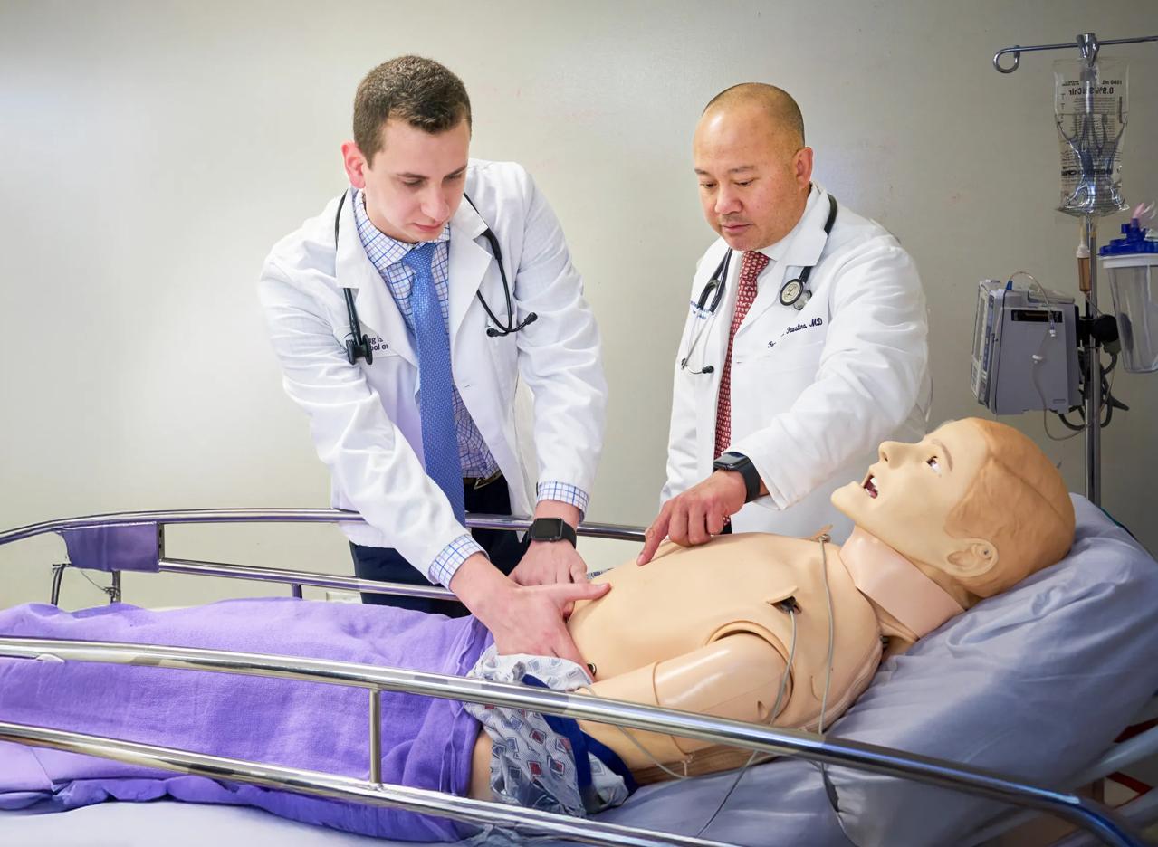Dr. Francis L. Faustino with an NYU Grossman Long Island School of Medicine student, taking part in patient simulation training at the Research and Academic Center.