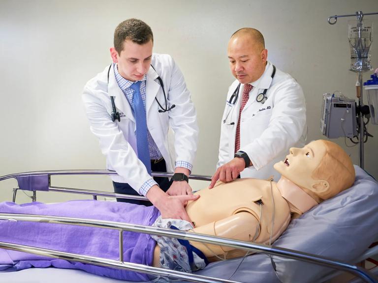 Dr. Francis L. Faustino with an NYU Grossman Long Island School of Medicine student, taking part in patient simulation training at the Research and Academic Center.