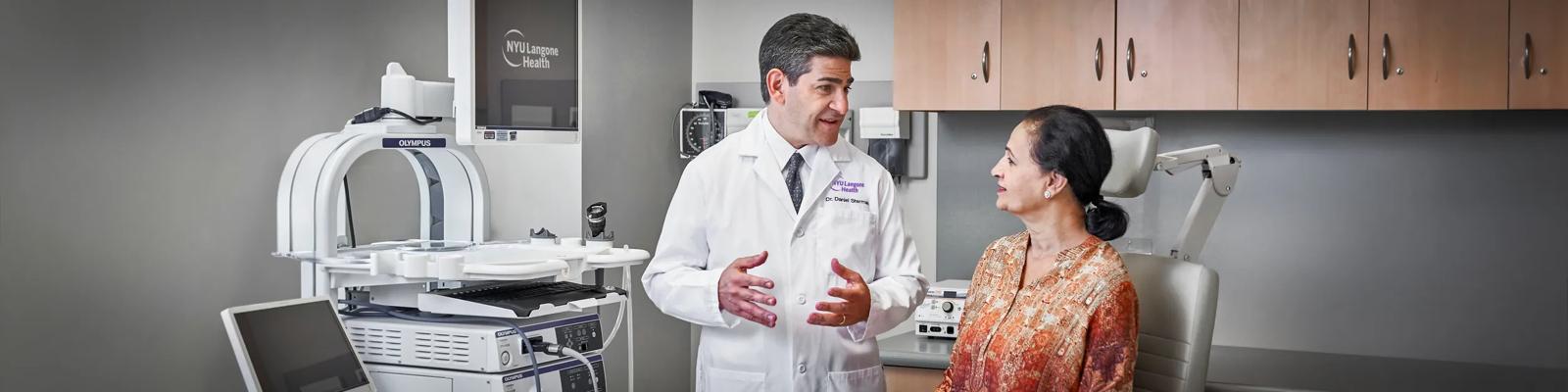 Dr. Daniel H. Sterman speaks with a female patient in an examing room.