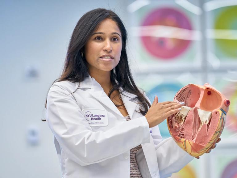 Shaline Rao, MD, holds and points to an anatomical heart model.