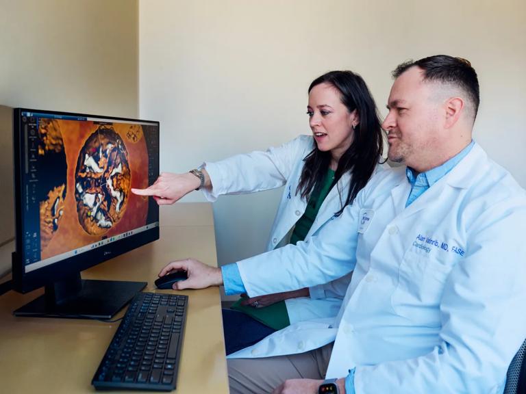 Alan Vainrib, MD, reviews a heart imaging scan on a computer monitor with Tara Collins, a physician assistant.