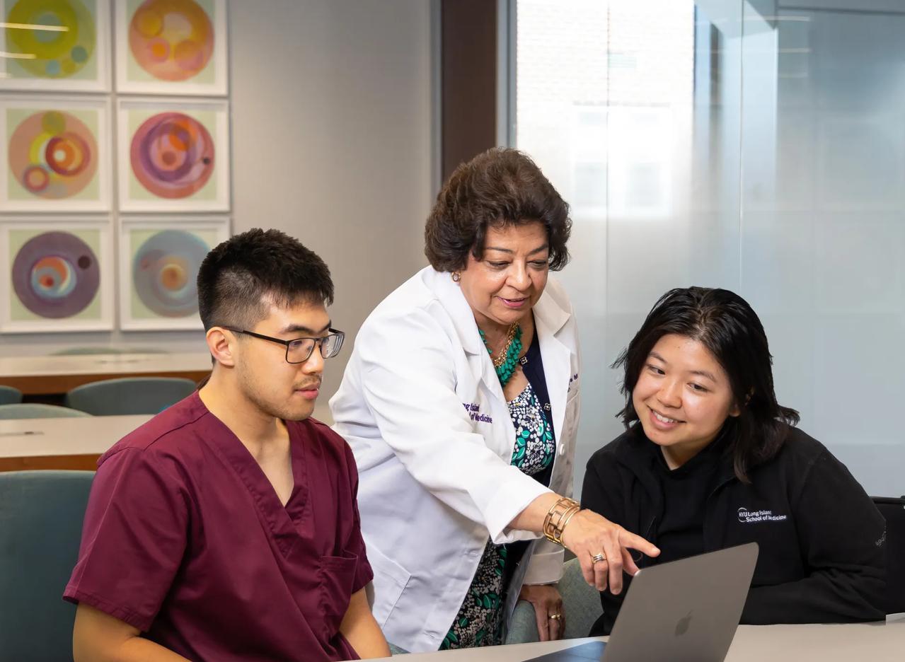 Dean Gladys Ayala talking with two students at NYU Grossman Long Island School of Medicine.