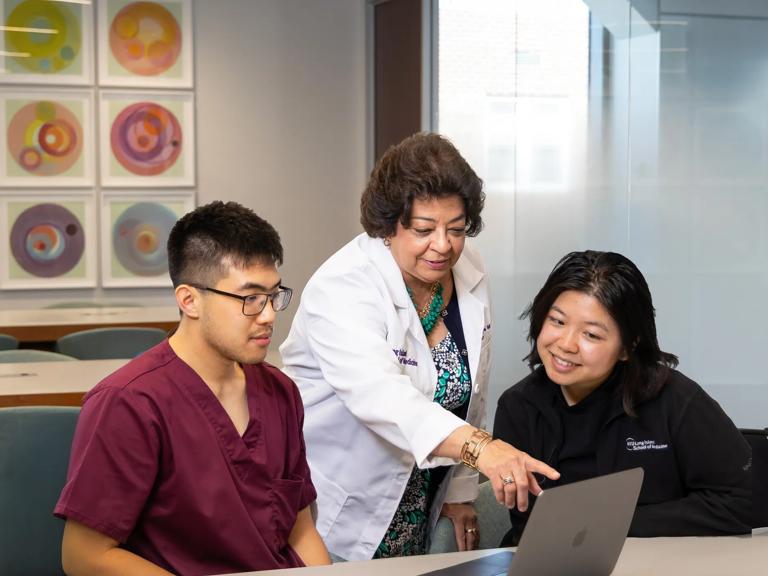Dean Gladys Ayala talking with two students at NYU Grossman Long Island School of Medicine.