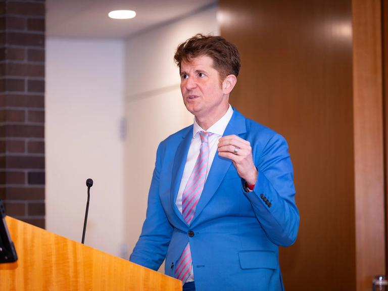 Leonardo Trasande, MD, speaks while standing at a podium.