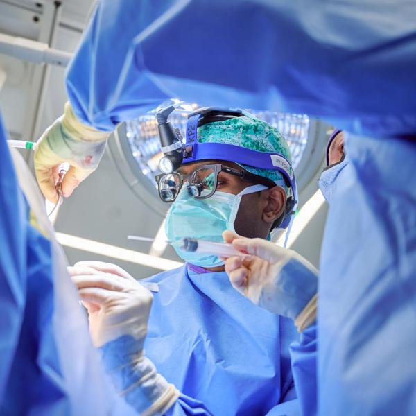 Carter Suryadevara, MD, PhD, performs neurosurgery in an operating room at Kimmel Pavilion.