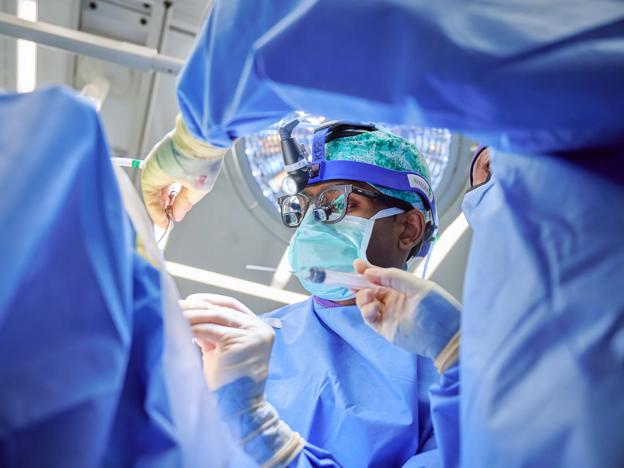 Carter Suryadevara, MD, PhD, performs neurosurgery in an operating room at Kimmel Pavilion.