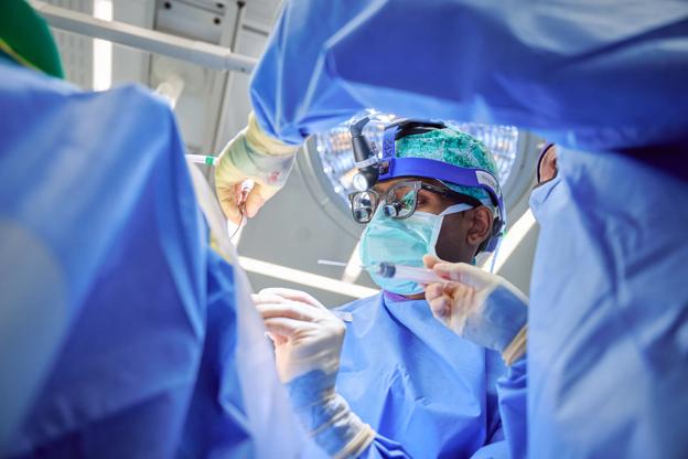 Carter Suryadevara, MD, PhD, performs neurosurgery in an operating room at Kimmel Pavilion.