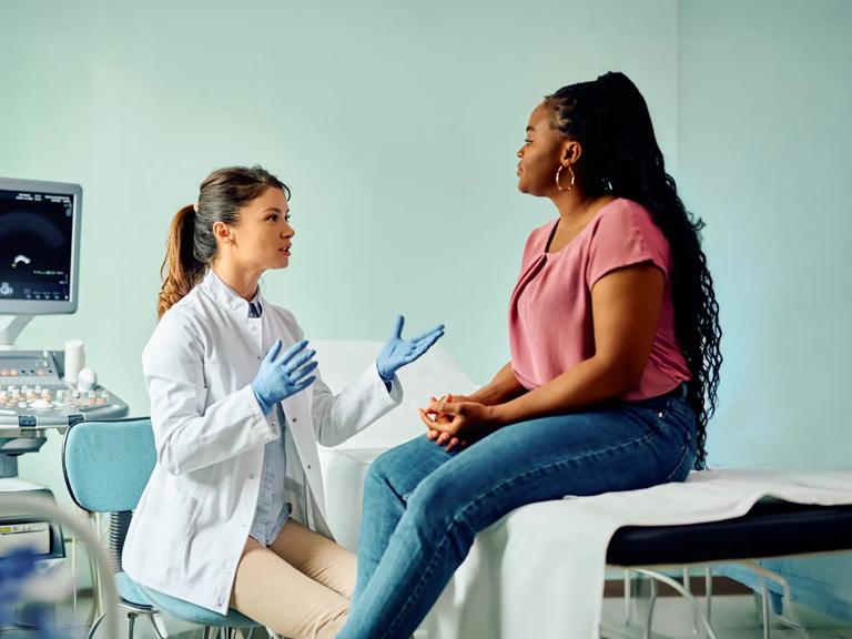 A doctor talks to a woman during medical examination at a clinic.