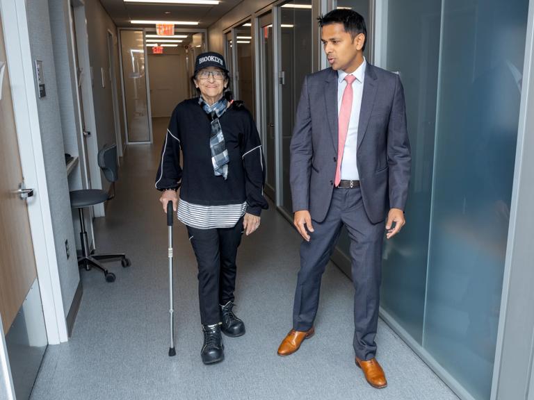 Kathleen Pastori, left, walks the halls at Tisch Hospital with Karan Garg, MD, right.