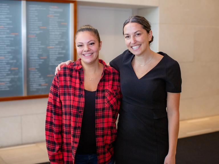 Dr. Deanna Gerber stands with her arm around the shoulders of Gabrielle Leon, and both are smiling.