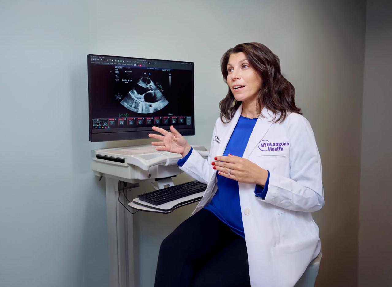 Michelle Bloom, MD, explains the results of an ultrasound image on a monitor in a patient room.
