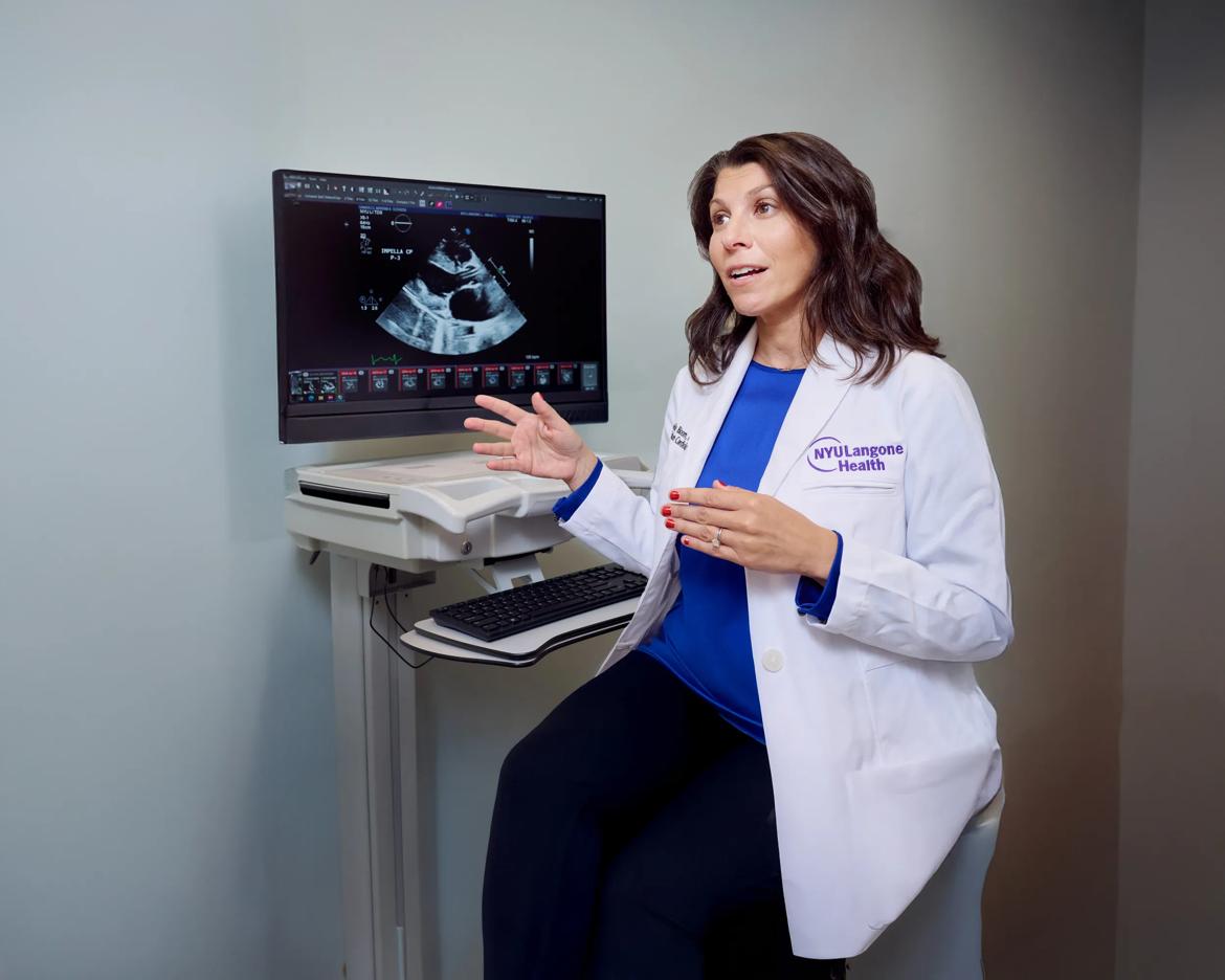 Michelle Bloom, MD, explains the results of an ultrasound image on a monitor in a patient room.