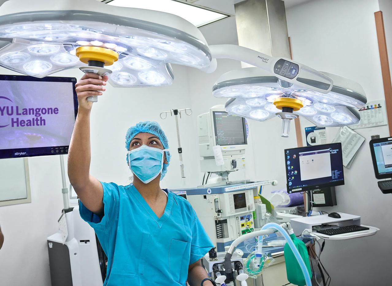 A doctor from the Department of Obstetrics and Gynecology at NYU Langone Hospital Long Island repositions an overhead surgical light.
