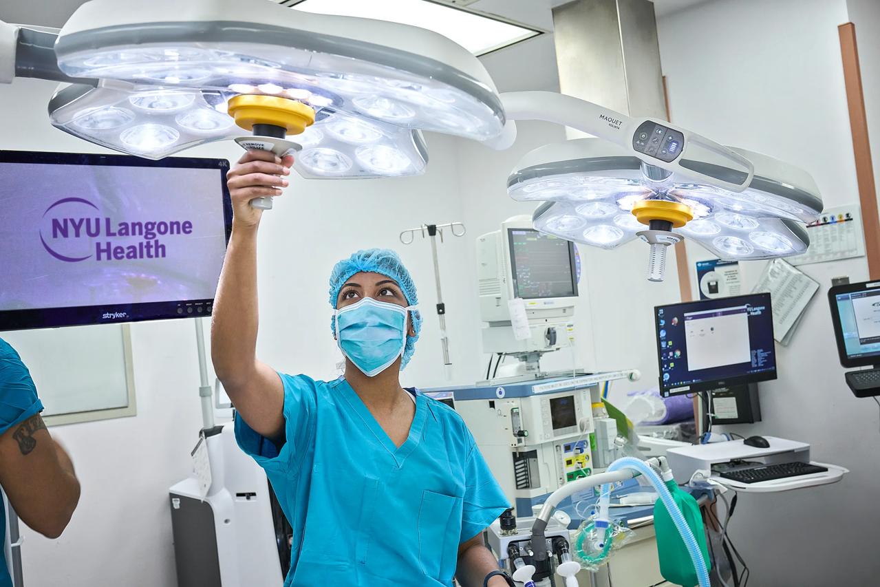 A doctor from the Department of Obstetrics and Gynecology at NYU Langone Hospital Long Island repositions an overhead surgical light.