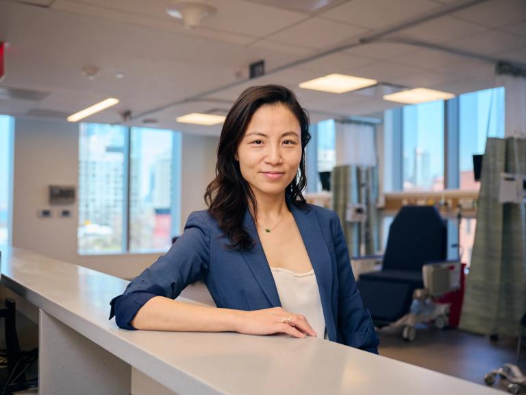 Kathy Huang, MD, pauses at the front desk of a patient care facility.