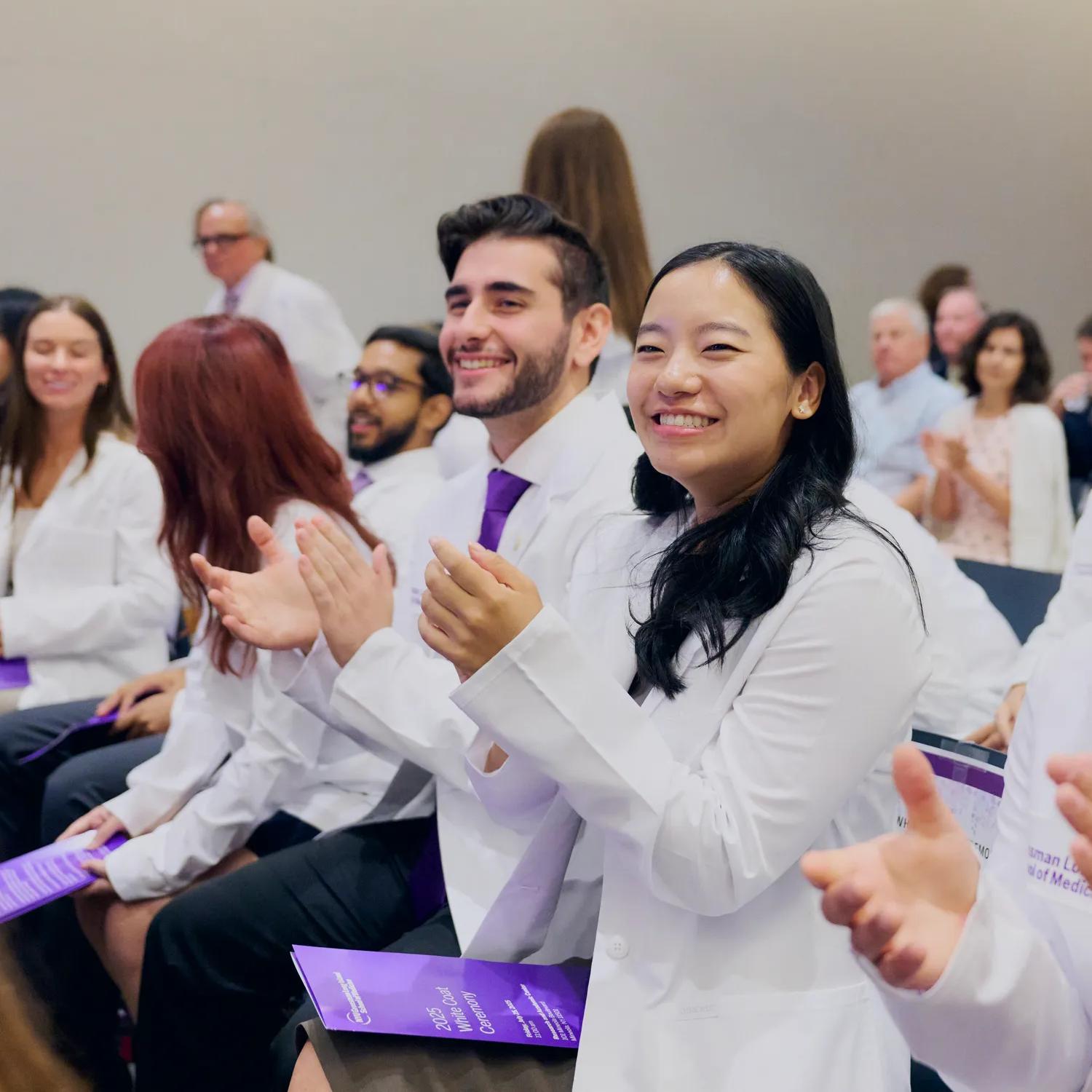 Medical students clap while sitting during the Grossman Long Island School of Medicine's 2025 White Coat Ceremony.