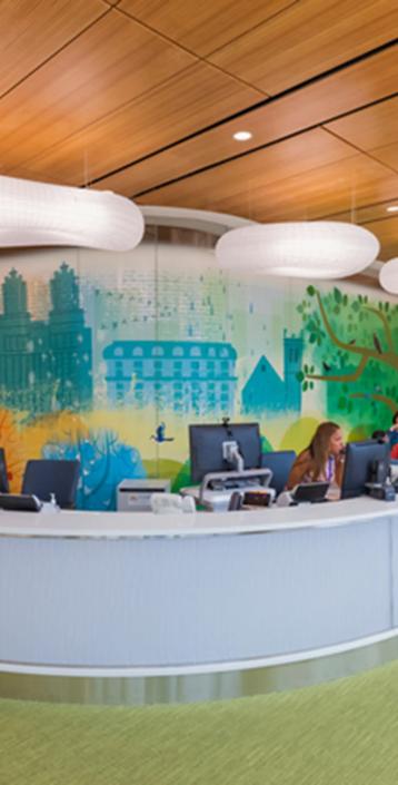 An NYU Langone employee speaks on the phone, and patients and caregivers sit in the waiting room at Hassenfeld Children's Hospital.