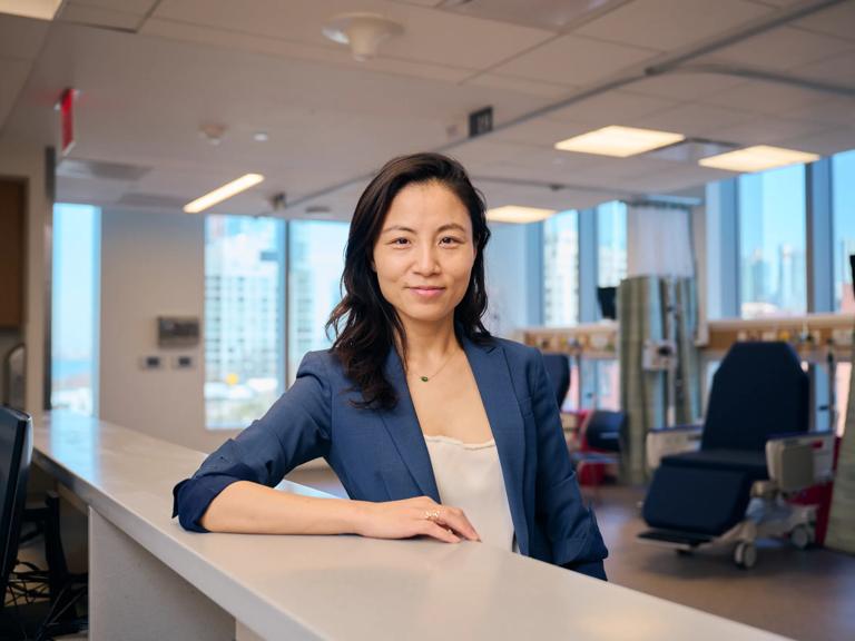 Dr. Kathy Huang pauses at the front desk of a patient care facility.